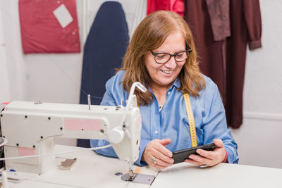 Portrait of woman using sewing machine