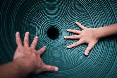 Cropped hands of friends touching turquoise surface