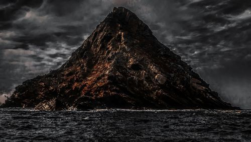 View of rock formation in sea against sky