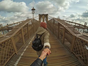 Rear view of woman on bridge against sky