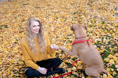 Full length of woman sitting on land during autumn