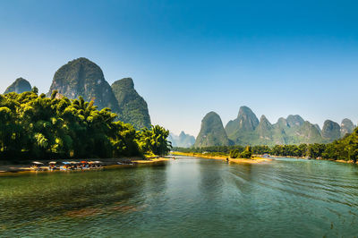 Scenic view of river and mountains against clear sky