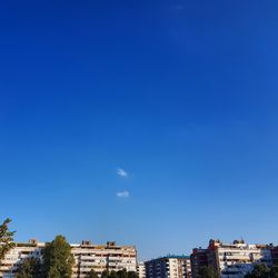 Low angle view of buildings against clear blue sky