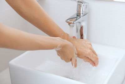 Cropped image of woman washing hands