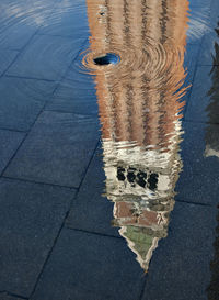 Reflection of tower on puddle in piazza san marco