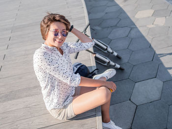 Wind ruffles short hair of woman. summer vibes. sincere emotions. kick scooter -  urban transport.
