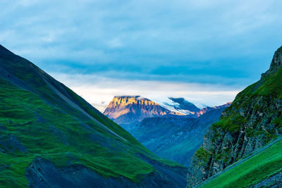 Scenic view of mountains against cloudy sky