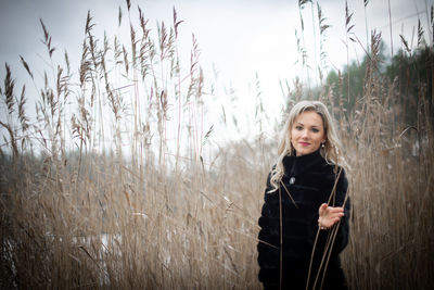 Portrait of smiling young woman standing on field