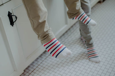 Low section of man standing on tiled floor