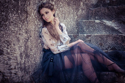 Portrait of a beautiful young woman sitting outdoors