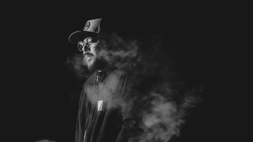 Man smoking cigarette against black background