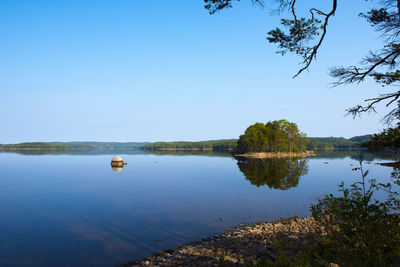 Scenic view of lake against clear blue sky