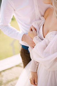 Midsection of couple embracing outdoors