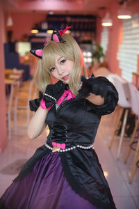 Portrait of young woman in costume standing at cafe