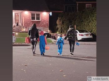 Rear view of people walking on road at night