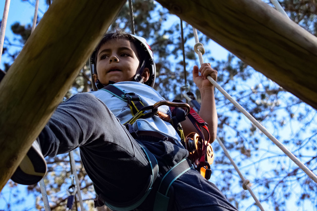 LOW ANGLE PORTRAIT OF BOY WITH ARMS OUTSTRETCHED