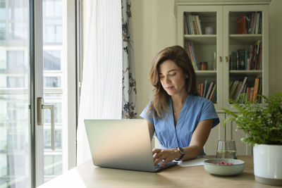 Businesswoman working on laptop at desk in home office