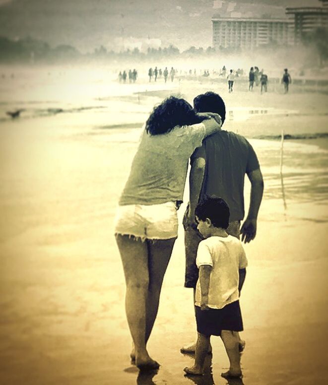 REAR VIEW OF FRIENDS STANDING ON BEACH