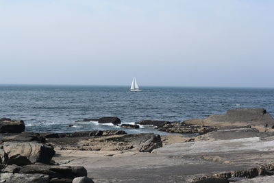 Sailboat in sea against clear sky