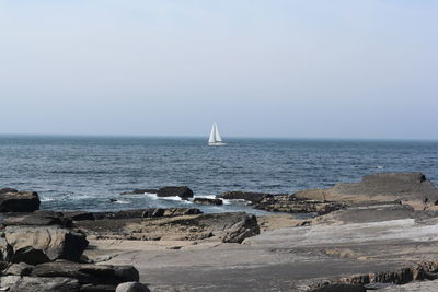 Sailboat in the horizon off valentia island, ireland
