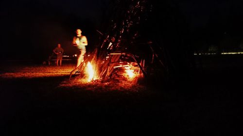 Bonfire on field against sky at night