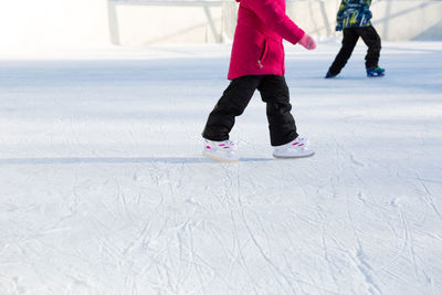 Low section of women walking on snow