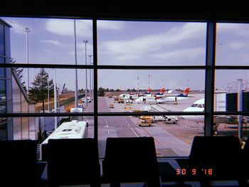 View of airport against sky seen through glass window