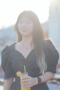 Portrait of young woman drinking glass