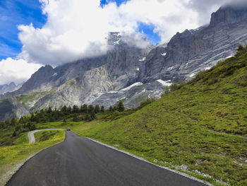 Road amidst green landscape against sky