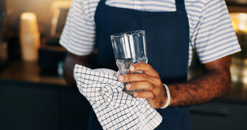 Midsection of man holding wineglass