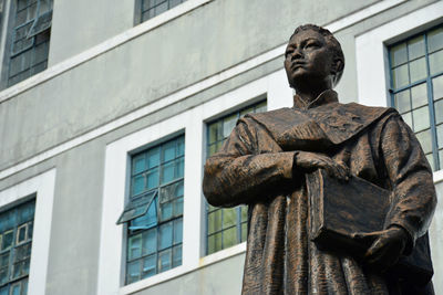 Low angle view of statue against building in city