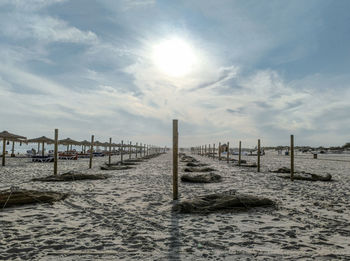 Wooden posts on beach against sky