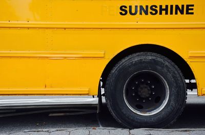 Close-up of yellow bus on road