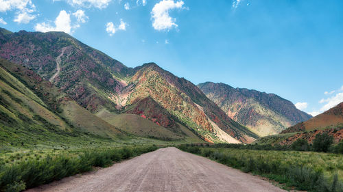 Road by mountain against sky