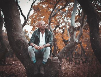 Low angle view of man sitting on tree