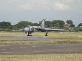 Airplane on runway against sky