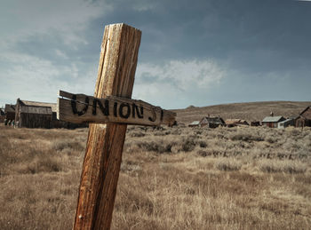 View of wooden post on field against sky