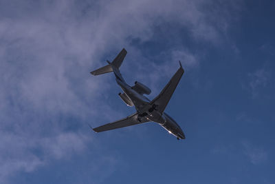 Low angle view of airplane flying against sky