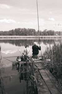 Rear view of father and son fishing at river