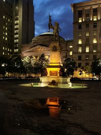 Statue in city at night