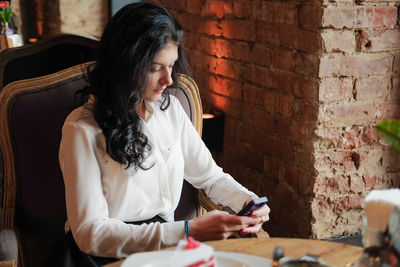 Businesswoman using mobile phone in restaurant