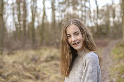 Portrait of a smiling young woman in forest