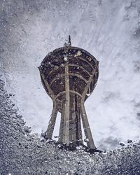 Low angle view of old tower against sky during winter