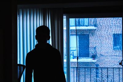 Rear view of man looking at window