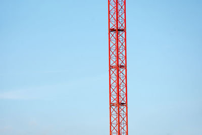 Low angle view of crane against clear blue sky
