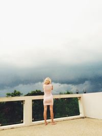 Rear view of woman standing against sky