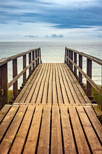 Surface level of pier on sea against sky