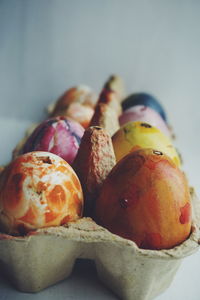 Close-up of painted easter eggs in carton against wall