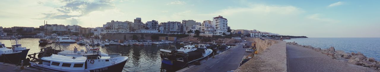 Panoramic view of buildings and sea against sky