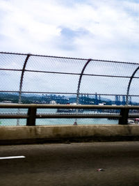 Close-up of bridge over sea against sky